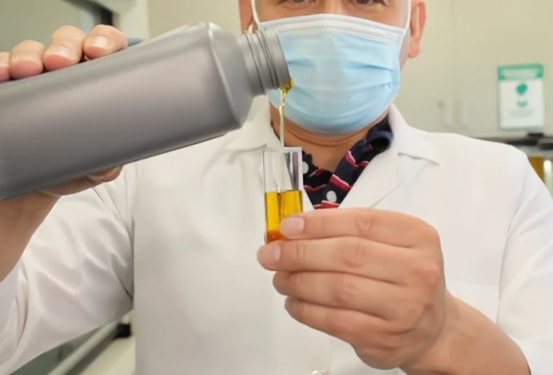 Lab technician pouring a sample into a test tube